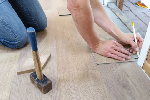 Installer measuring and marking flooring before a cut