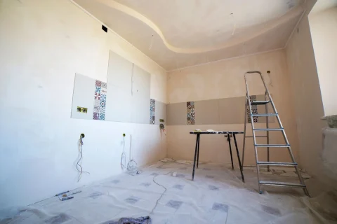 Bathroom under renovation with wall tile samples and a ladder