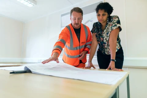 Contractor and client reviewing plans on a table
