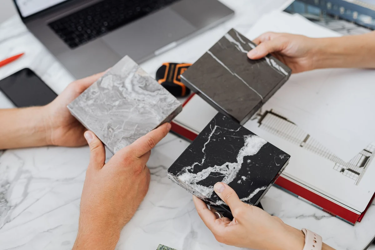 Comparing marble tile samples on a desk