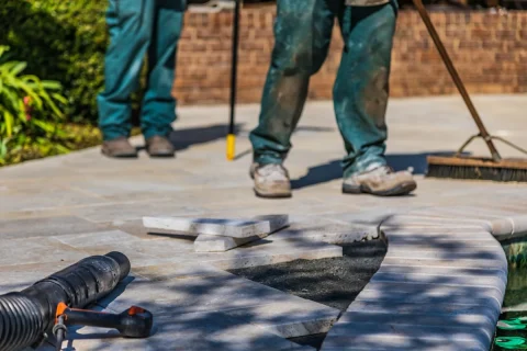Workers laying tile on an outdoor patio